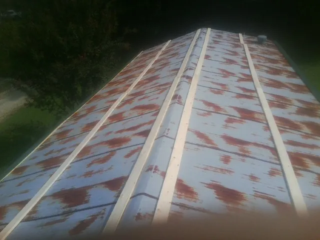 Rusted metal roof panels with new wood purlins before replacement — Storm Damage Roof Repair in Saginaw by Roofing Brothers