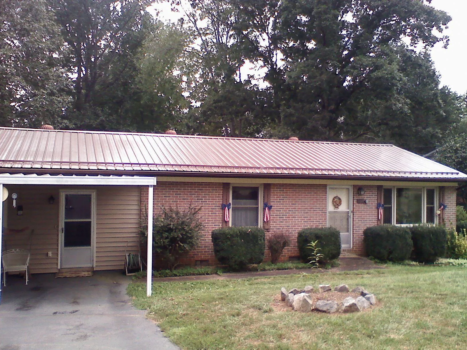 Bronze metal roof and carport on a brick ranch home — Roof Repair work by our crew in Saginaw